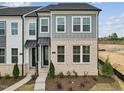 A close-up of a gray and white modern townhome exterior with brick accents and manicured landscaping at 810 Barlow Dr, Knightdale, NC 27545