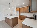 Gourmet kitchen with quartz countertops, a kitchen island, custom cabinets, and modern lighting at 810 Barlow Dr, Knightdale, NC 27545