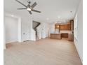 Open-concept living space featuring light hardwood floors, neutral paint, and a modern ceiling fan at 810 Barlow Dr, Knightdale, NC 27545
