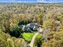 Sprawling estate nestled amidst lush trees with a pristine pool, showcasing privacy and elegance at 110 Bywater Way, Chapel Hill, NC 27516