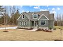 Gray farmhouse exterior with stone accents, landscaping and a partially visible driveway at 25 Basil Ct, Franklinton, NC 27525