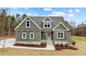 New construction home with gray siding, stone accents, and a front porch at 25 Basil Ct, Franklinton, NC 27525
