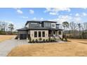 Eye-catching two-story home with a three-car garage, stone accents, professional landscaping, and a concrete driveway at 30 Hartwood Ln, Youngsville, NC 27596