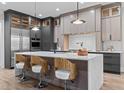 Stylish kitchen with a waterfall island, pendant lighting, stainless steel appliances, and custom cabinetry at 30 Hartwood Ln, Youngsville, NC 27596