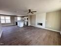 Open living room with a fireplace, kitchen island, and hardwood floors at 48 Silver Ct, Smithfield, NC 27577