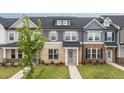 Charming townhome with a brick facade, blue door, and a well-manicured lawn at 937 Alma Railway Dr # 555, Wake Forest, NC 27587