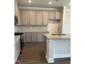 Bright kitchen features gray cabinets, stainless steel appliances, granite countertops, and a center island with sink at 937 Alma Railway Dr # 555, Wake Forest, NC 27587