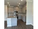 Stylish kitchen features gray cabinets, stainless steel appliances, granite countertops, and hardwood flooring at 937 Alma Railway Dr # 555, Wake Forest, NC 27587