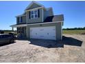 Charming two-story home with a two car garage, green siding, black shutters, and a well-manicured front yard at 195 Sawyer Mill Dr, Dunn, NC 28334