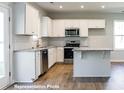 Modern kitchen with white cabinets, stainless steel appliances, and a center island at 195 Sawyer Mill Dr, Dunn, NC 28334