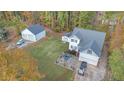 Aerial view of a well-maintained home with a two-car garage, detached garage and brick patio nestled in a wooded setting at 143 Rawhide Dr, Louisburg, NC 27549