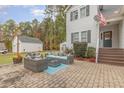 A charming outdoor brick patio features a cozy seating arrangement, ideal for relaxation and entertaining at 143 Rawhide Dr, Louisburg, NC 27549