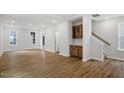 Bright, open living space with hardwood floors, neutral paint, and a built-in bar area near the stairway at 276 White Oak Garden Way # 210, Garner, NC 27529