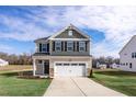 Two-story home with a green and beige exterior and a two-car garage at 65 Wild Turkey Way Way, Lillington, NC 27546