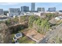 Aerial view of a vacant lot for sale in neighborhood with surrounding trees and city skyline in background at 216 Dartmouth Rd, Raleigh, NC 27609
