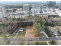 Aerial view of a vacant lot for sale with surrounding neighborhood and city skyline in the distance at 216 Dartmouth Rd, Raleigh, NC 27609