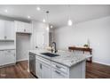 White kitchen with large island, granite countertops, and stainless steel appliances at 257 Circle City Way, Pittsboro, NC 27312