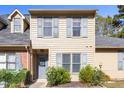 Charming two-story home with light-colored siding and grey shutters surrounded by landscaping and a small American flag at 14 Stone Village Ct, Durham, NC 27704