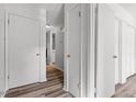 Hallway featuring wood-look flooring and white doors leading to other rooms in the home at 14 Stone Village Ct, Durham, NC 27704