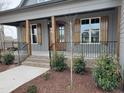 Charming front porch with wooden posts, decorative shutters, and a stylish front door entrance at 20 Water Willow Ln, Zebulon, NC 27597