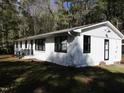 White ranch house with black window frames and a spacious lawn at 213 Drew St, Louisburg, NC 27549