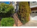 A brick staircase with black iron railings leads to a covered front entrance, framed by lush greenery at 229 Rose Walk Ln, Carrboro, NC 27510