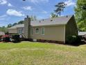 Backyard view featuring a deck, mature trees, and well-maintained lawn at 6220 Sweden Dr, Raleigh, NC 27612