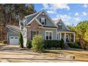 Charming home featuring a partial brick facade, light blue siding, and a well-manicured lawn and driveway at 181 Colonial Ridge Dr, Pittsboro, NC 27312