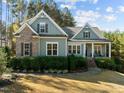 Attractive home with lush landscaping, stone steps, and a welcoming front porch for relaxing at 181 Colonial Ridge Dr, Pittsboro, NC 27312
