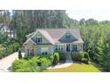 Inviting home featuring charming curb appeal with lush landscaping, brick accents, and an open front porch at 181 Colonial Ridge Dr, Pittsboro, NC 27312