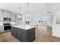 Modern kitchen with island, stainless steel appliances, and white cabinets at 444 Billingshurst Way, Knightdale, NC 27545