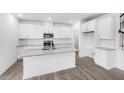 Bright kitchen features white cabinetry, granite countertops, stainless steel appliances and large center island at 657 Sun Meadow Dr, Wake Forest, NC 27587