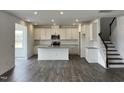 Bright kitchen featuring white cabinets, stainless steel appliances, an island, and hardwood floors at 657 Sun Meadow Dr, Wake Forest, NC 27587