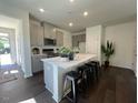 Open kitchen features gray cabinets, stainless steel appliances, and an island with seating at 120 Parker Ln, Mebane, NC 27302