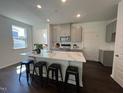 Bright kitchen features stainless steel appliances, an island with bar stool seating, and modern finishes at 120 Parker Ln, Mebane, NC 27302