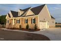 View of the exterior with brick and siding and the three car garage at 1665 S Old Carriage Rd, Rocky Mount, NC 27804