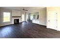 Spacious living room with dark wood floors, fireplace and white trim open to the kitchen area at 1665 S Old Carriage Rd, Rocky Mount, NC 27804