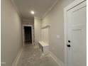 Well-lit hallway with built-in storage bench, adding functionality and style to the home at 102 Roma Gora Ct, Princeton, NC 27569