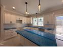 Modern kitchen featuring ample white cabinetry, large island, and plenty of natural light at 102 Roma Gora Ct, Princeton, NC 27569