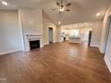 Open-concept living room with fireplace, hardwood floors, and seamless flow into the kitchen at 102 Roma Gora Ct, Princeton, NC 27569