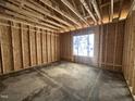 Framed interior space with plywood walls and a window, showing the rough structure of the room at 104 Roma Gora Ct, Princeton, NC 27569