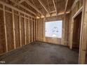 Framed interior space with plywood walls and a window, showing the rough structure of the room at 104 Roma Gora Ct, Princeton, NC 27569