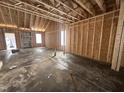 Unfinished living room featuring exposed framing and natural light from windows at 106 Roma Gora Ct, Princeton, NC 27569