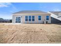 Home's back elevation, showcasing a patio and a large backyard at 1221 Cricket St, Elon, NC 27244