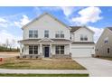 Attractive two-story home featuring a charming covered porch and well-manicured lawn at 1233 Cricket St, Elon, NC 27244
