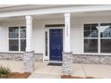Welcoming front entrance with a navy blue door framed by stone-accented columns and bright windows at 1233 Cricket St, Elon, NC 27244