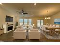 Bright and airy living room showcasing a fireplace, large windows, and an adjacent dining area with modern decor at 34 Mcintosh Ct, Fuquay Varina, NC 27526