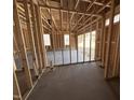Garage in framing stage featuring concrete slab flooring, wood framing, and natural light at 612 Tuscany Cir, Princeton, NC 27569