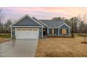 Beautiful home with an attached garage, neat lawn, and lovely sunset at 613 Tuscany Cir, Princeton, NC 27569