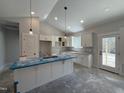 Modern kitchen features white cabinets, granite countertops, a large island, and stainless hardware at 702 Tuscany Cir, Princeton, NC 27569